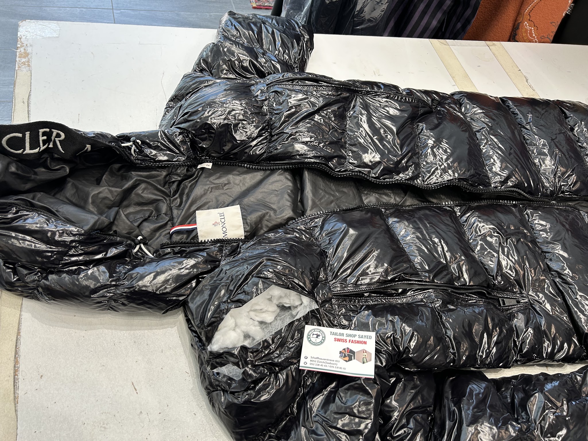Schwarze Daunenjacke auf dem Arbeitstisch mit offener Füllung