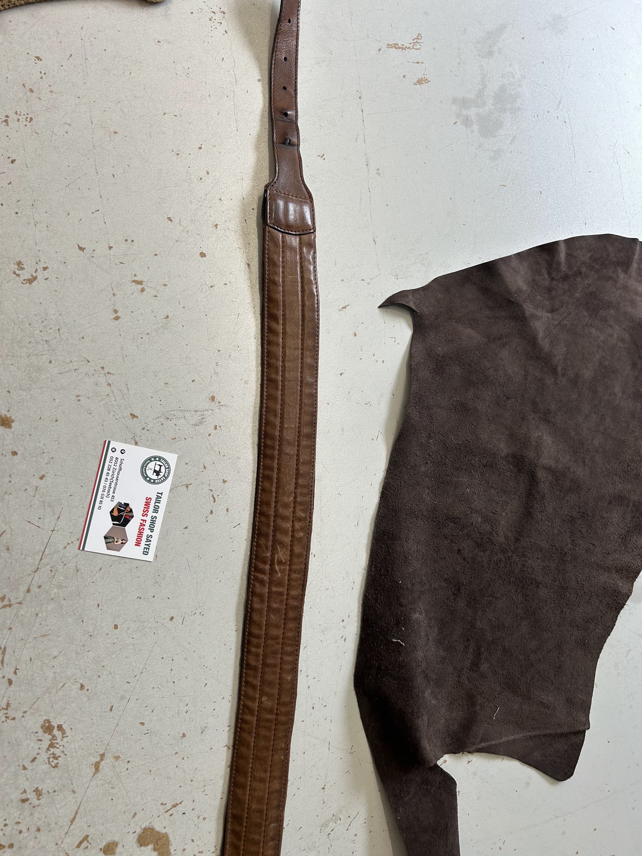 Brauner Ledergürtel neben einem Stück Veloursleder